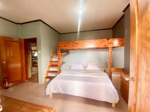 Baguio mountain villa view LW في باغيو: غرفة نوم مع سرير بطابقين وسلم