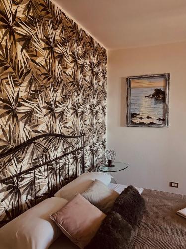 a bedroom with a wall with a flower pattern at Tyche House Castelmola in Castelmola
