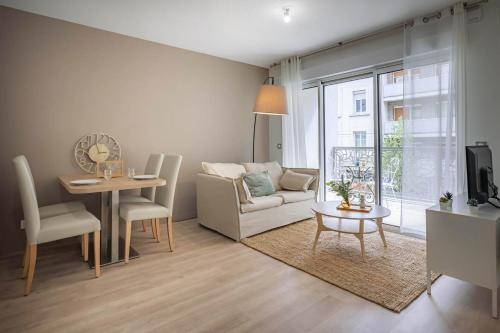 un salon avec un canapé et une table dans l'établissement OVELIA Saint-Etienne - Les Arches de la Montat, à Saint-Étienne