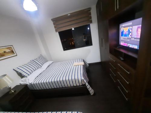 a living room with a bed and a flat screen tv at Ámbar B3-P15-TC in Cochabamba