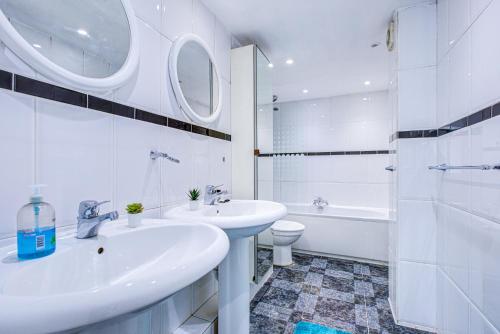Dubai Creek Budget Apartment في دبي: حمام أبيض مع حوض ومرحاض