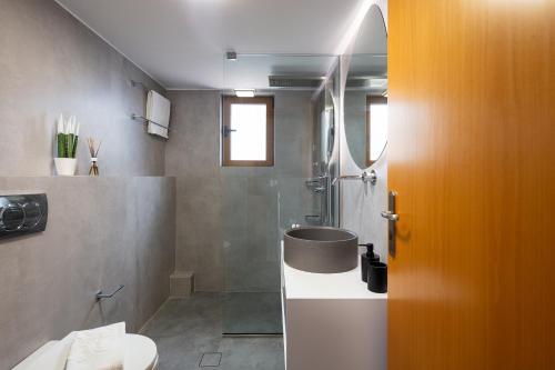 uma casa de banho com um chuveiro, um WC e um lavatório. em Maroulas Villas Ioanna & Stavros, stunning views, By ThinkVilla em Maroulás