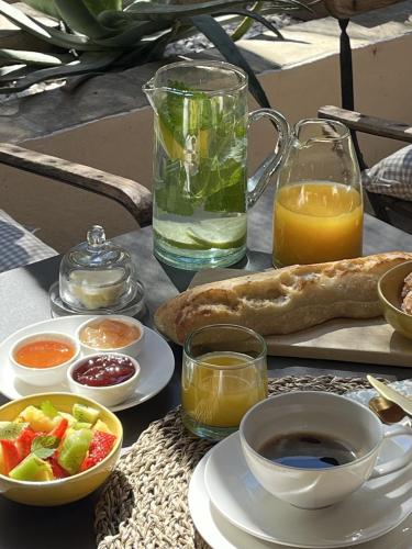 a table with a plate of food and a glass of juice at Maison Olea in Marseille