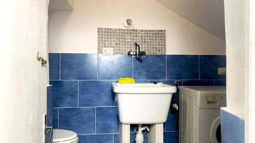 La salle de bains est pourvue de carrelage bleu, de toilettes et d'un lavabo. dans l'établissement la casa della Poetessa, à Orte