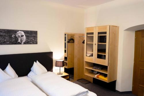 a bedroom with a bed and a cupboard and a bed sidx sidx at Hotel Garni Löwen in Silz