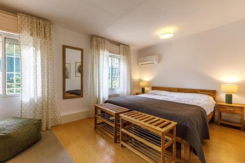 a bedroom with a bed and a chair and windows at Villa Los Pinos 6 in Altea