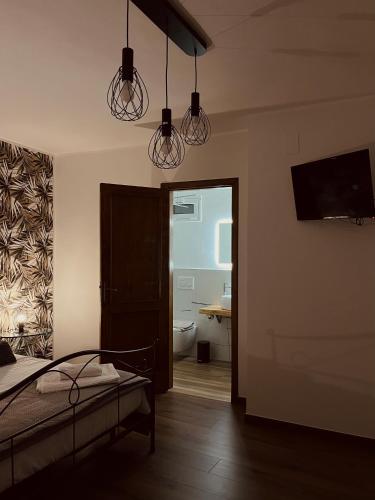 a bedroom with a bed and a bathroom with a toilet at Tyche House Castelmola in Castelmola