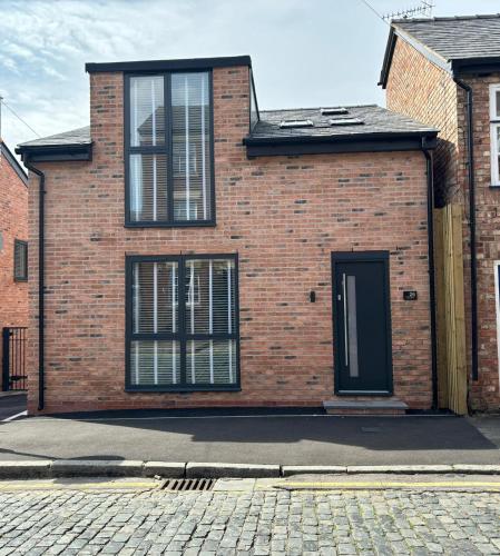 a brick house with a black door on a street at Pilgrim House by Phoenix Collection in Liverpool