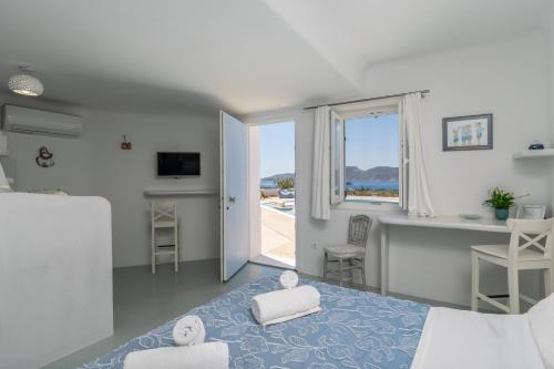 a bedroom with a bed and a view of the ocean at Blu Suites and Studios in Adamas