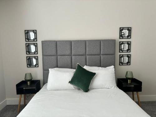 a bedroom with a large white bed with a green pillow at Pilgrim House by Phoenix Collection in Liverpool