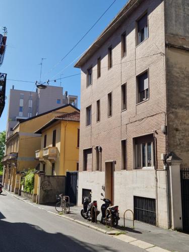 un grupo de motocicletas estacionadas al lado de un edificio en Studio Luna Apartments, en Milán