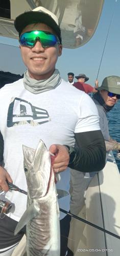 Un uomo che tiene un pesce su una barca. di Dubai fishing trip 5 hours a Dubai