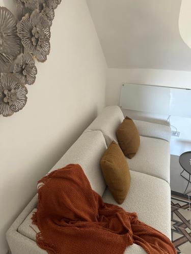 a living room with a couch with a blanket on it at Suite Sami Charming Home in Ostuni