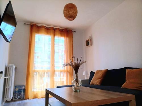 un salon avec un vase de fleurs sur une table dans l'établissement Beau 3 pièces de 65m2 climatisé, à Nice