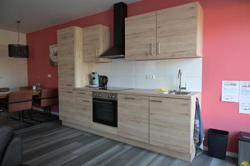 - une cuisine avec des placards en bois, un évier et une table dans l'établissement B&B gewoon Prins, à Wichmond