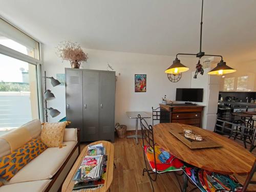 un salon avec un canapé et une table dans l'établissement Vos vacances les pieds dans le sable., à Saint Pierre La Mer