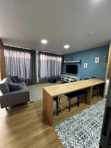 a living room with a table and a couch at Apartamento Matriz PVZ (T2) in Póvoa de Varzim