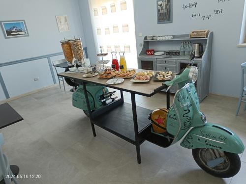 a scooter parked next to a table with food on it at Villa Mariana Bed and Breakfast in Saluzzo