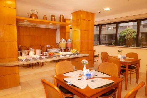 Un restaurante con mesas y sillas en una sala. en Rede Andrade Canada, en Río de Janeiro