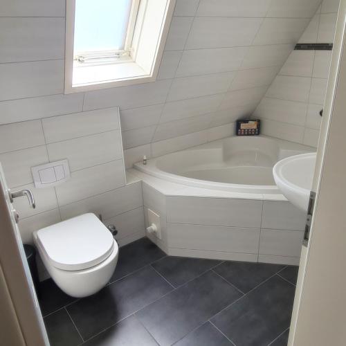 a bathroom with a toilet and a tub and a sink at Castello Apartment Boppard in Boppard