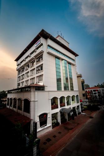 a large white building sitting on the side of a street at Daan Orchid Residency in Kottayam
