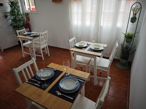 a dining room with two tables and chairs with plates and wine glasses at La concha in La Laguna