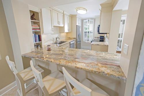 a kitchen with a marble counter top and white cabinets at 3 Bedroom 2 Bath Sandpiper Condo with Ocean Views in Pawleys Island