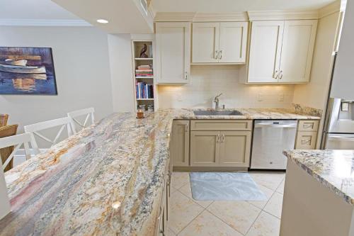 a kitchen with white cabinets and a marble counter top at 3 Bedroom 2 Bath Sandpiper Condo with Ocean Views in Pawleys Island