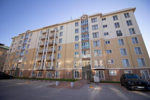 a large building with a car parked in a parking lot at 3 Rooms A502 StayInn by Cosmopolis in Bucharest