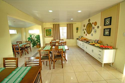 eine Küche und ein Esszimmer mit Tischen und Stühlen in der Unterkunft Hotel Pousada Delplata in Serra Negra