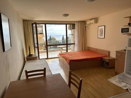 a room with a bed and a table and a window at Julia Vigo Panorama apartments in Nesebar