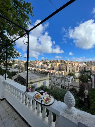 a plate of food on a balcony with a view of a city at chambre standard elbiar in El Biar