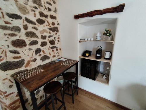 um quarto com uma mesa de madeira e dois bancos em Bed And Breakfast Villa Bianca em Orosei