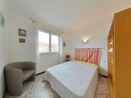 une chambre avec un lit, une chaise et une fenêtre dans l'établissement Appartement avec balcon proche plage, à Saint Pierre La Mer
