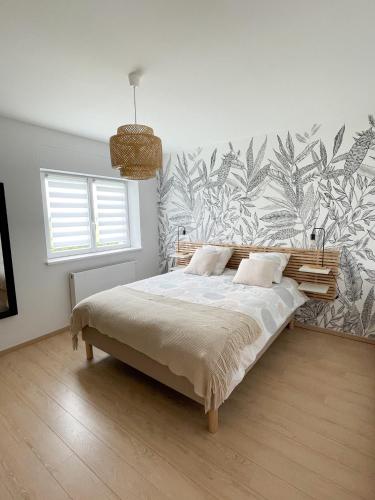 une chambre avec un lit avec un papier peint tropical dans l'établissement Villa de standing en Champagne, à Fresnes-lès-Reims