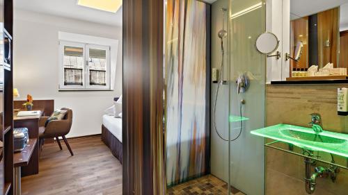 Habitación con baño con lavabo y ducha. en Hotel Deutsche Eiche en Múnich