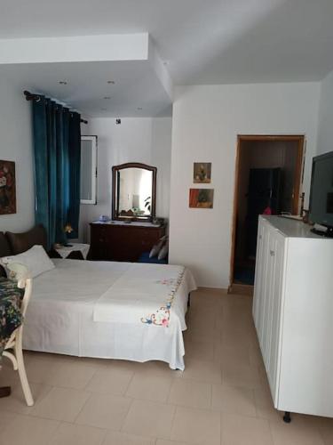 a bedroom with a white bed and a mirror at Στούντιο στο κέντρο της Πρέβεζας in Preveza