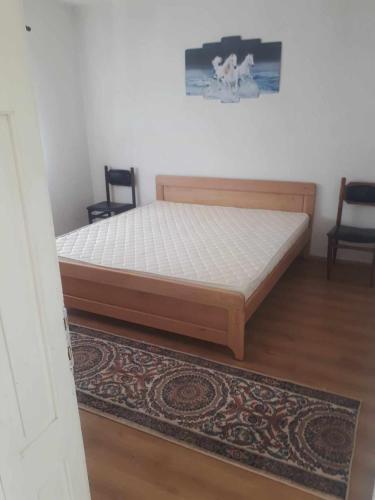 a bed in a bedroom with two chairs and a rug at HOLIDAY HOME - NEGREVO in Pehčevo