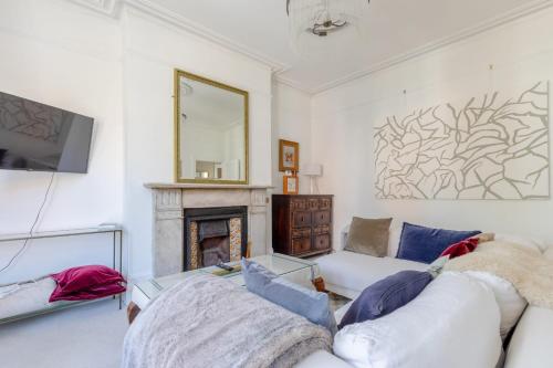 een woonkamer met een bank en een open haard bij Elegant 1BD Victorian Flat Hampstead Heath! in Londen