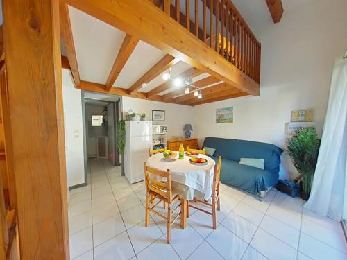 un salon avec une table et un canapé bleu dans l'établissement Pavillon T3 avec grande terrasse et résidence avec piscine et tennis, à Saint Pierre La Mer
