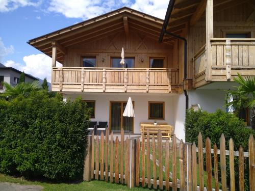 a house with a wooden fence in front of it at Chalet Schaller in Tesimo