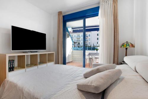 貝納爾馬德納的住宿－Apartamento Lola，一间卧室设有一张大床和一台平面电视。