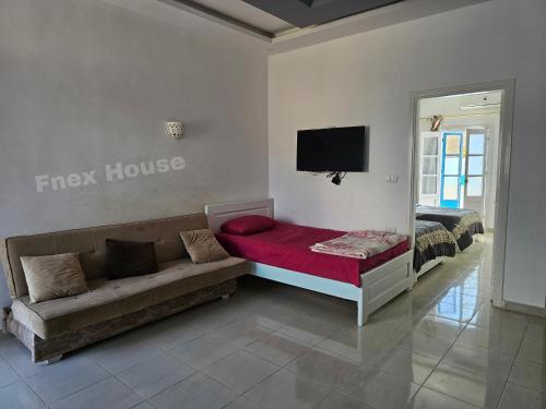 a living room with a couch and a flat screen tv at Fnex House in Dahab