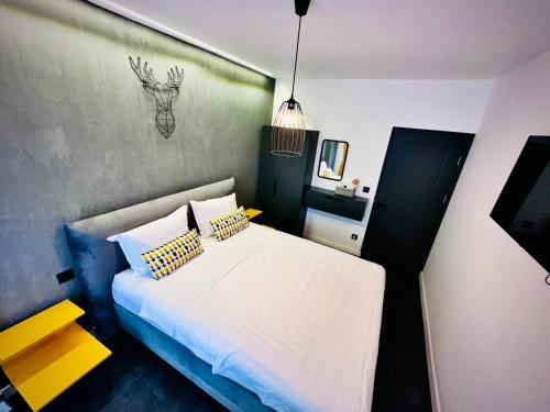 małą sypialnię z białym łóżkiem z poduszkami w obiekcie Central Place to Stay w mieście Reşiţa