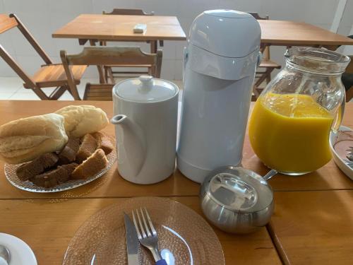 a table with a breakfast of bread and orange juice at VIRASSOL Praia Hotel in Salvador