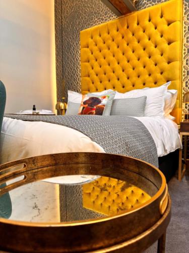 a bedroom with a large bed with a yellow headboard at Quite Simply French in Lancaster