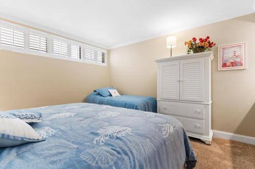 a bedroom with a blue bed and a dresser at 3 Bedroom 2 Bath Sandpiper Condo with Ocean Views in Pawleys Island