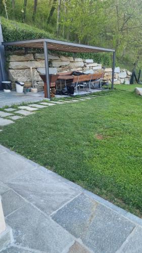 a picnic table and benches in a park at Ca' del magu in San Michele Mondovì