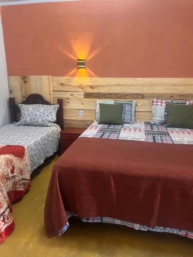 a bedroom with two beds and a lamp at Pousada Recanto do Tucano in Cavalcante