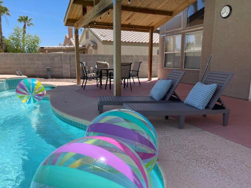 a pool with a table and chairs and a ball in the water at Pool House Newly Remodeled 3bed 3bath Near DT Summerlin and Red Rock in Las Vegas